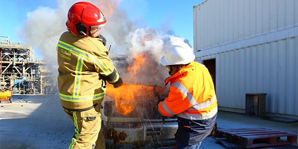 firefighter trainer with his trainee on a vehicle fire exercise